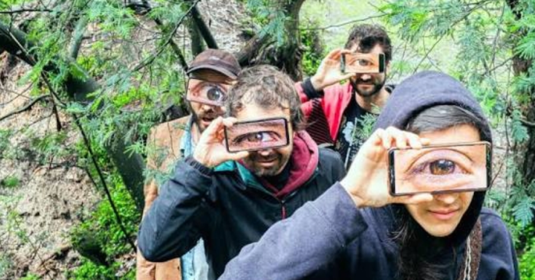 Imagen de cuatro (4) hombres que tienen un celular en la mano proyectando sus ojos.