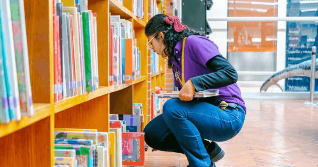 Imagen de funcionaria organizando catálogo de libros en BibloRed Bogotá.