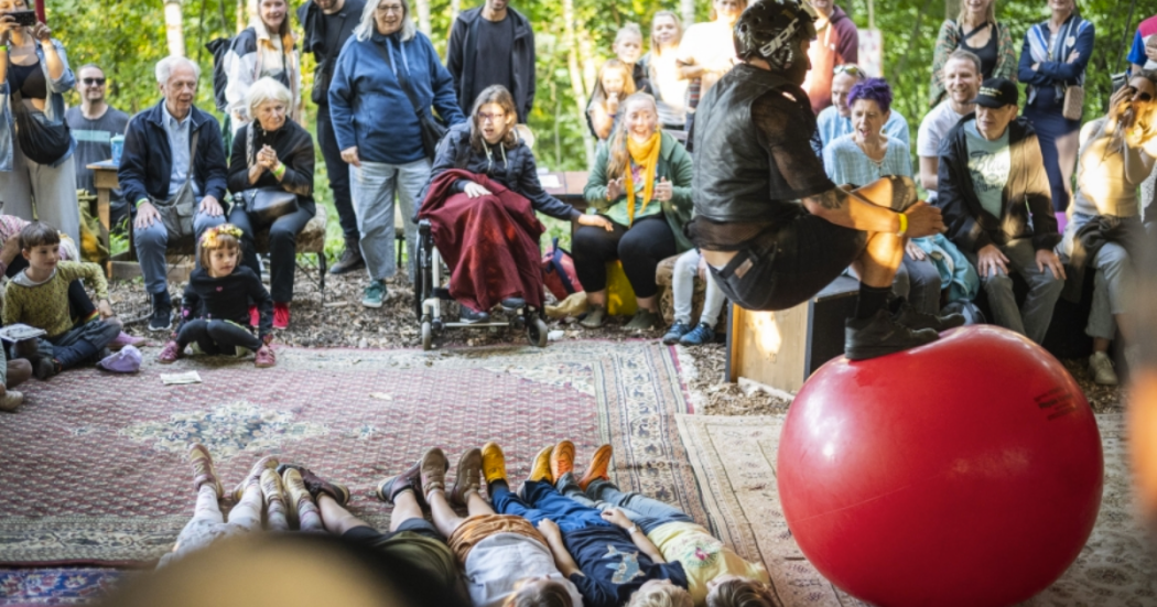 Imagen de varias personas disfrutando de la actividad, hay varios niños acostados en fila.