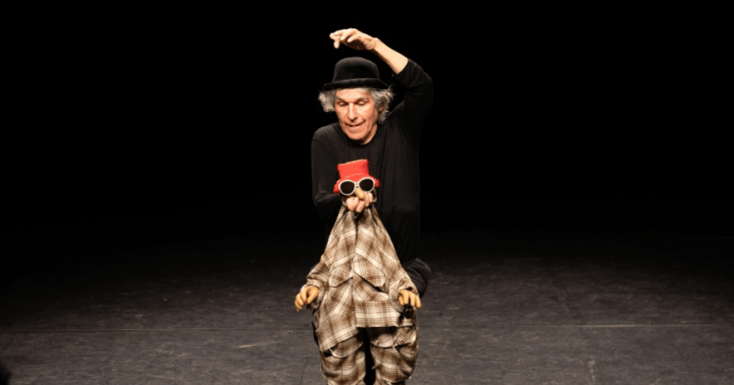 Foto de un hombre con un títere en una obra de teatro en Bogotá.
