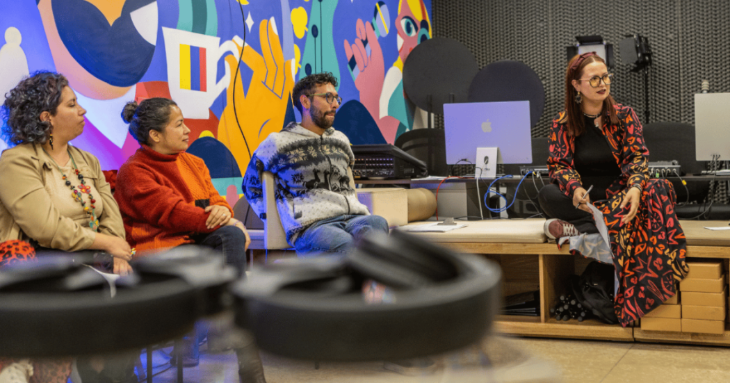Imagen de varias personas en un estudio donde hay varios computadores.