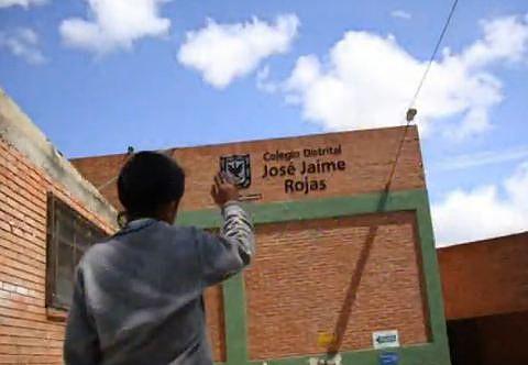 Niño de espaldas observa la fachada de uno de los colegios del Distrito.