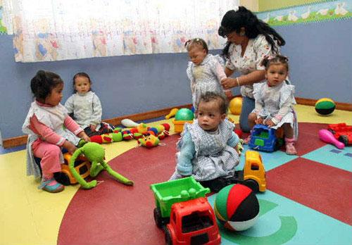 Niños pequeños juegan en una aula infantil.