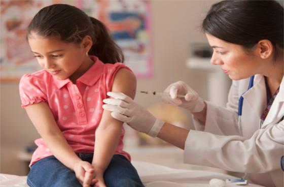 Médica aplica una vacuna a una niña.