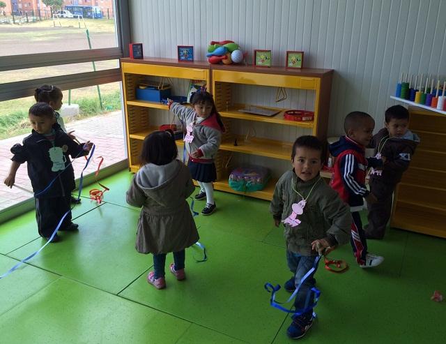 Plano general de un grupo de niños jugando en un jardín infantil.