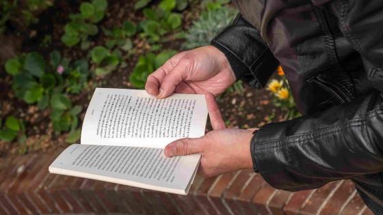 Foto de un hombre leyendo un libro en un espacio abierto en Bogotá.