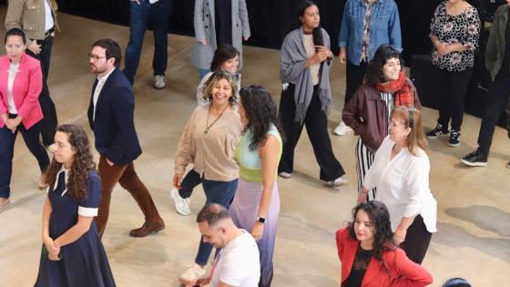 Foto de hombres y mujeres en una sala caminando.