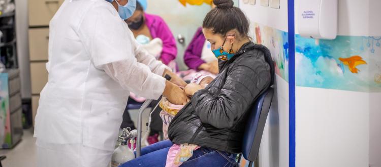 Enfermera atendiendo a mamá y su bebé