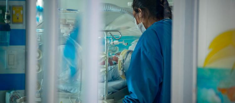 Doctora junto a una incubadora 