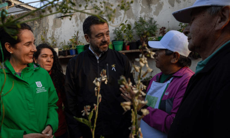 Foto del alcalde Galán hablando con una señora en un jardín
