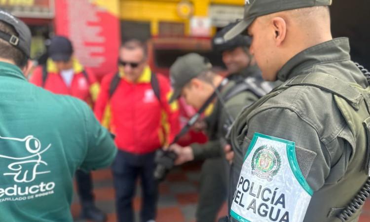 Foto de un policía del Agua en Bogotá con otros funcionarios