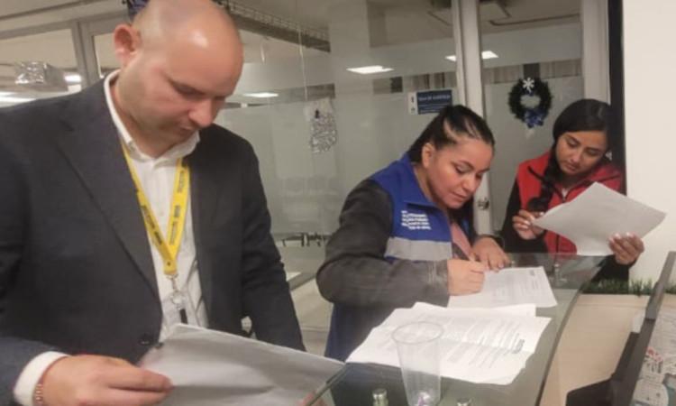 Foto que muestra personas firmando papeles