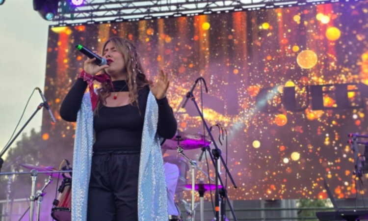 Imagen de una mujer cantando en una tarima