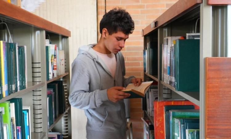 Foto que muestra un joven leyendo un libro 