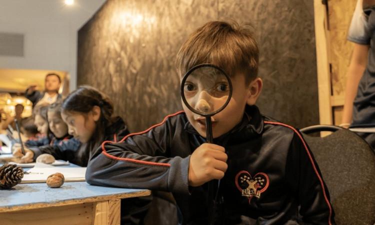 Foto que muestra un niño con una lupa 