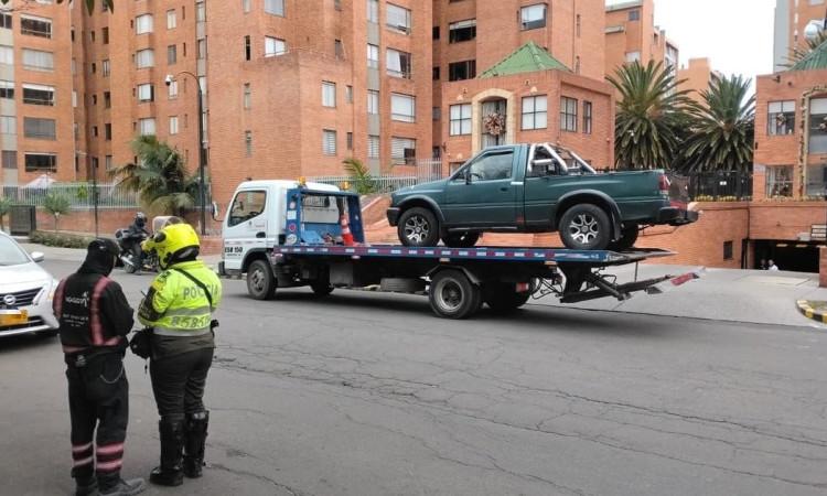 Foto de un agente de tránsito junto a una grúa