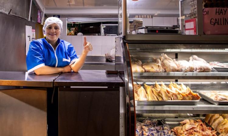 Foto de una comerciante y su negocio.