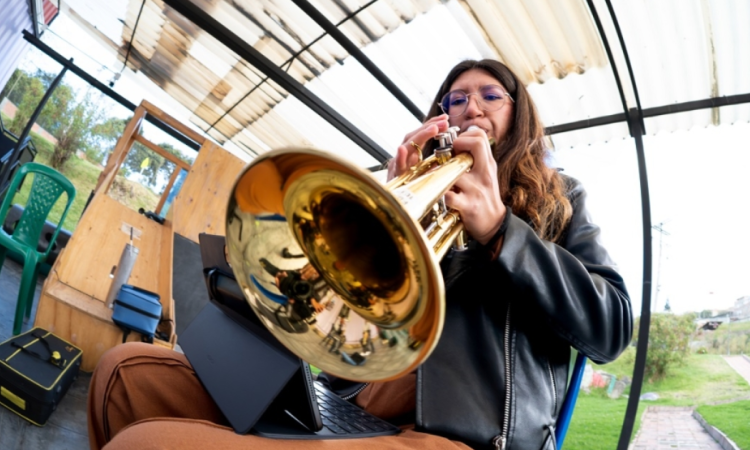 Imagen de una mujer jóven tocando un instrumento músical de viento.