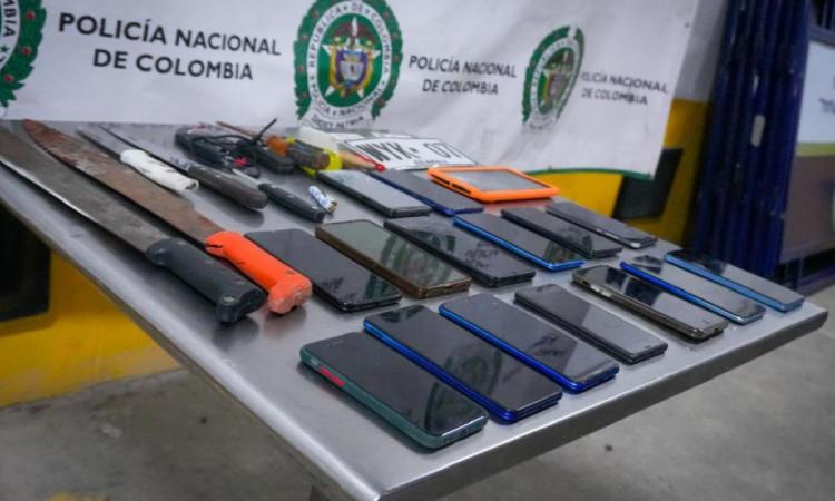 Foto que muestra celulares y armas sobre una mesa 