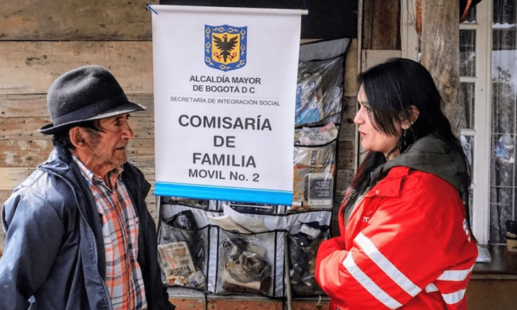 Imagen de una funcionaria de Integración Social junto a un adulto mayor