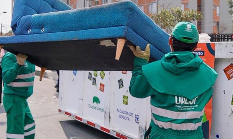 Foto que muestra dos personas levantando un sofá
