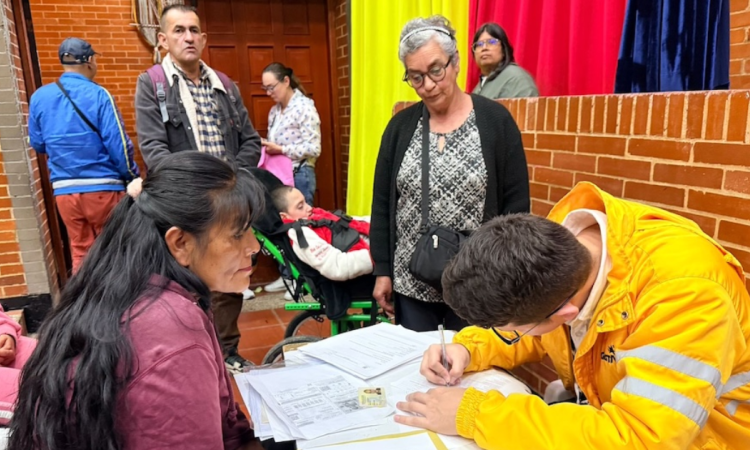 Imagen de un funcionario de Integración Social atendiendo a una mujer y llenando un formulario