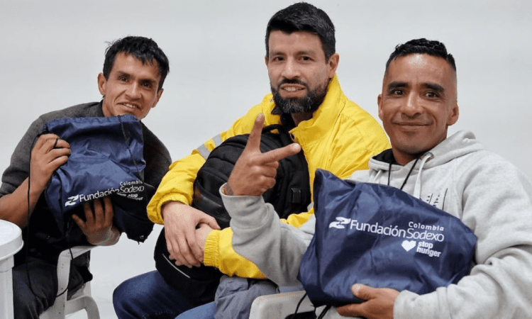 Imagen de tres personas con sus kits escolares