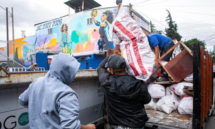 Foto que muestra una persona dejando una bolsa en un ecopunto