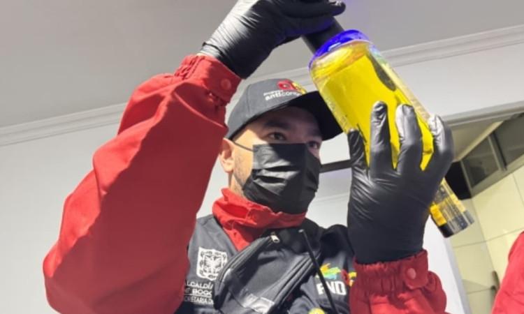 Foto de un funcionario realizando verificación de botellas de licor durante los controles en el centro de Bogotá.