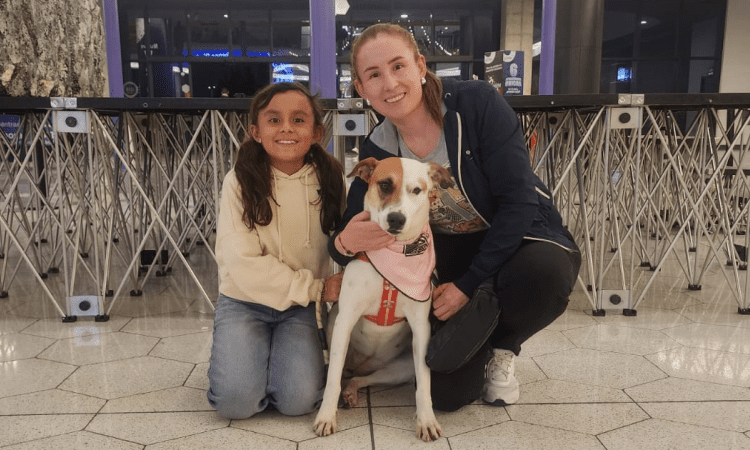 Imagen de una señora con una niña y una perrita recién adoptada