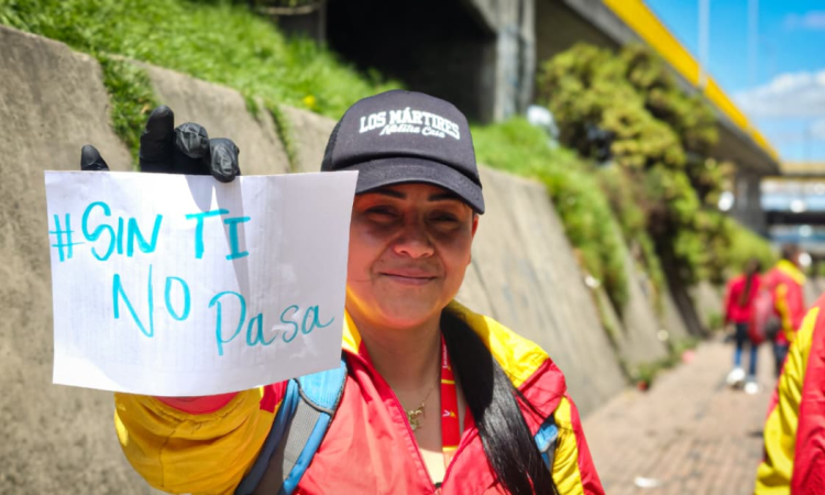 Foto de una funcionaria del Distrito con un cartel 