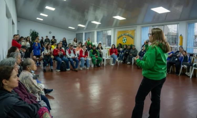 Foto que muestra un grupo de personas reunidas en un salón 