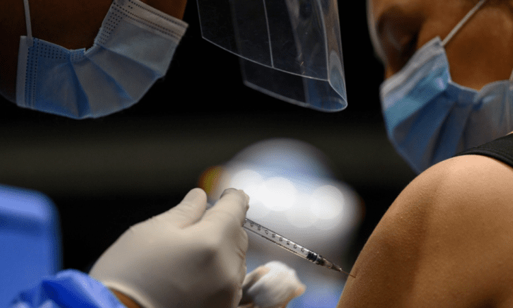 Foto de una enfermera colocando una vacuna en el hombro de una persona