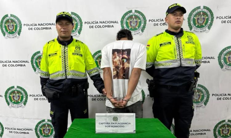 Hombre capturado por presunto homicidio, entre dos uniformados.