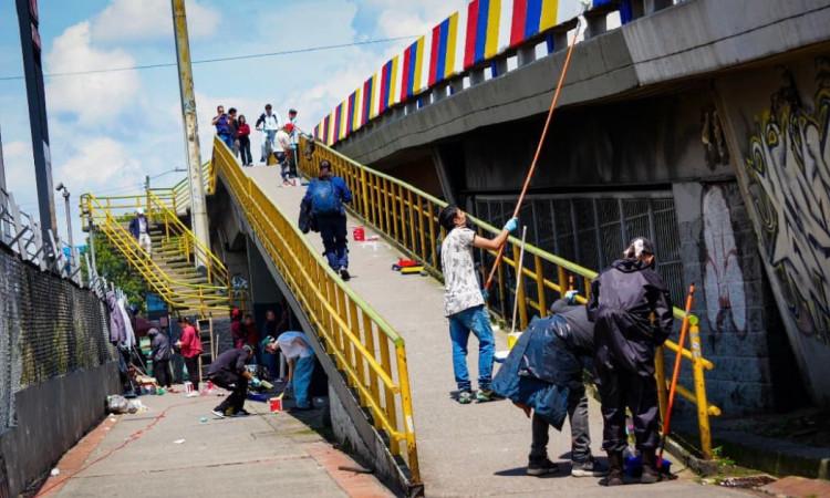 Infractores saldando deuda con ciudad pintando un mural en puente vehicular.