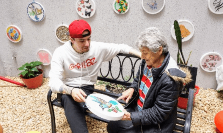 Imagen de un joven junto a una señora persona mayor