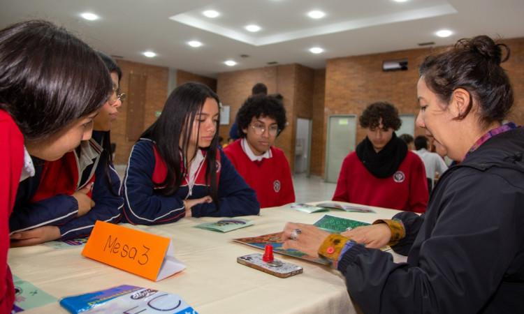 Foto que muestra estudiantes sentados en una mesa 