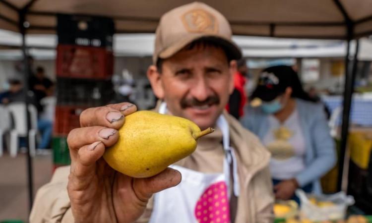 Un campesino mostrando una pera