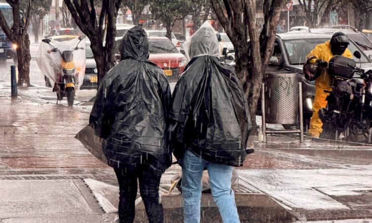 Foto que muestra personas caminando bajo la lluvia 