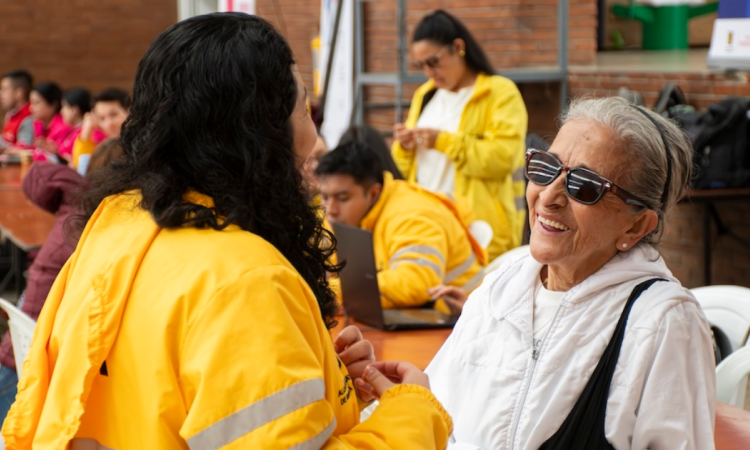 Imagen de una señora sonriendo junto a una funcionaria de Integración Social