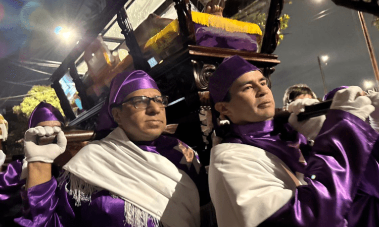 Imagen de dos hombres cargando un imagen de jesucristo