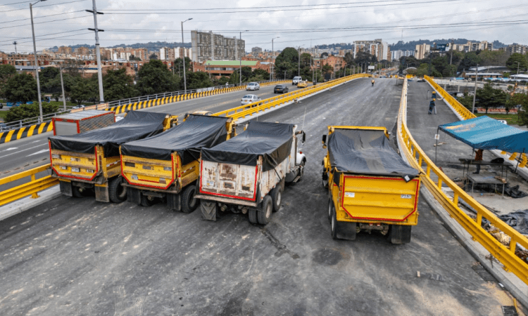 Imagen de tres volquetas en el puente de la 153
