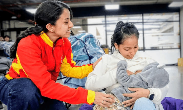 Imagen de una funcionaria con una madre que carga a su bebé
