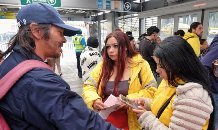 Imagen de una funcionaria hablando con un habitante de calle en una estación de TransMilenio