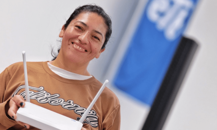 Imagen de una señora sonriendo y sosteniendo un rauter
