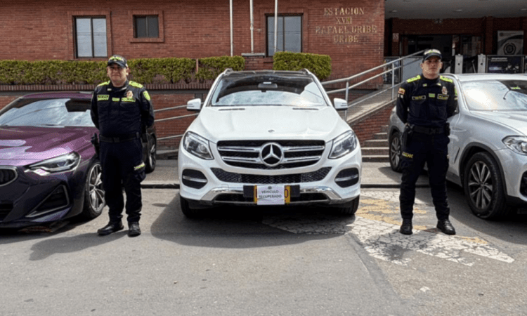 Imagen de dos policías junto a los vehículos recuperados