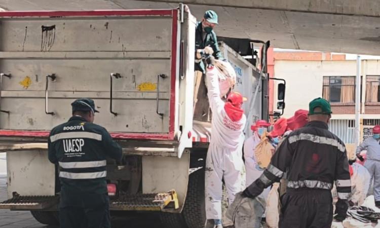 Foto que muestra personas recolectando residuos en una volqueta