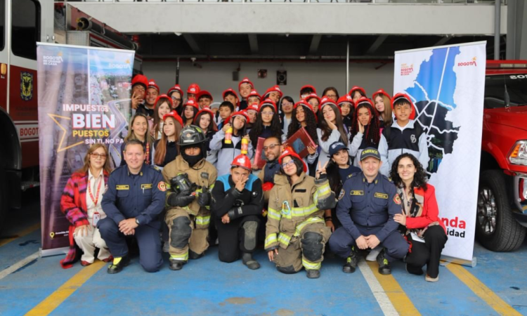 Imagen de niños y niñas posando para una foto en la estación de Bomberos