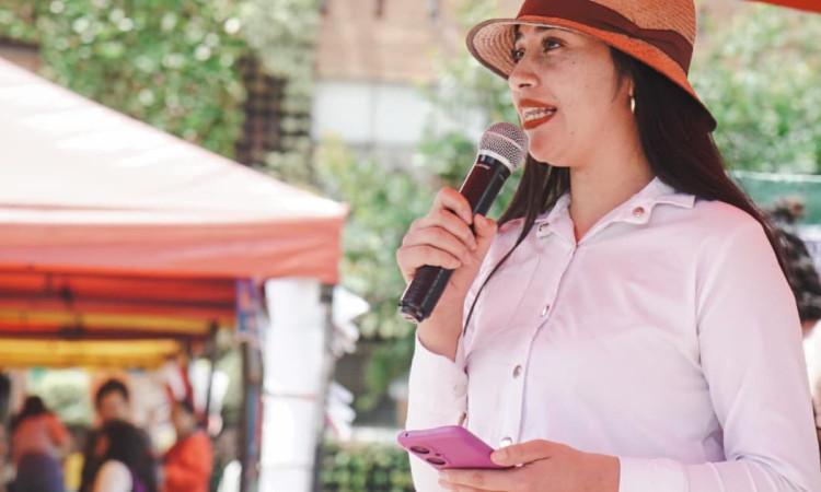 Mujer de la ruralidad bogotana hablando por un micrófono ante el público