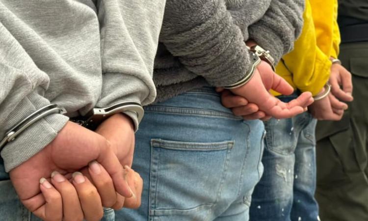 Personas esposadas por la Policía 